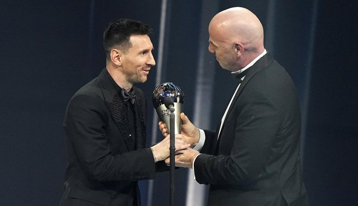 Presiden FIFA, Gianni Infantino, memberikan trofi penghargaan kepada Lionel Messi sebagai pemain terbaik FIFA 2022 di Paris, Selasa (28/2/2023). (AP Photo/Michel Euler)