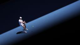 Petenis Kanada, Denis Shapovalov melakukan pukulan balik saat melawan petenis Spanyol, Rafael Nadal dalam pertandingan perempat final tunggal putra pada hari kesembilan turnamen tenis Australia Terbuka di Melbourne pada 25 Januari 2022.
(AFP/Martin Keep)