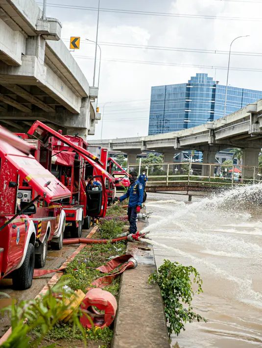 Petugas pemadan kebakaran menyedot air banjir di kawasan Cipinang Melayu, Jakarta, Minggu (21/2/2021). Suku Dinas Pemadam Kebakaran Jakarta Timur mengerahkan 20 mobil pompa untuk menyedot air yang membanjiri RW 04 Kelurahan Cipinang Melayu untuk mengurangi debit air. (Liputan6.com/Faizal Fanani)