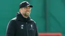 Pelatih Liverpool, Jurgen Klopp tersenyum saat melihat para pemainnya berlatih selama latihan tim di Melwood, Inggris (6/5/2019). Pada leg pertama Liverpool kalah telak atas Barcelona 3-0 di Stadion Nou Camp. (AFP Photo/Lindsey Parnaby)