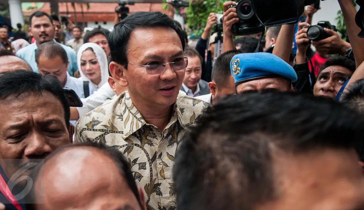 Tersangka kasus dugaan penistaan agama, Basuki Tjahaja Purnama (Ahok) berusaha menerobos kerumunan wartawan setibanya di gedung Kejagung, Jakarta, Kamis (1/12). Ahok masih tetap memilih bungkam saat ditanya awak media. (Liputan6.com/Gempur M Surya)