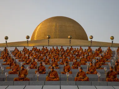 Biksu Buddha menghadiri perayaan Makha Bucha di tengah pandemi COVID-19, di Wat Dhammakaya, Bangkok, Jumat (26/2/2021). Perayaan Makha Bucha merupakan upacara keagaamaan terbesar di Thailand. Pada perayaan itu, warga Buddha bersembahyang dan memberikan sedekah kepada para biksu. (Jack TAYLOR/AFP)