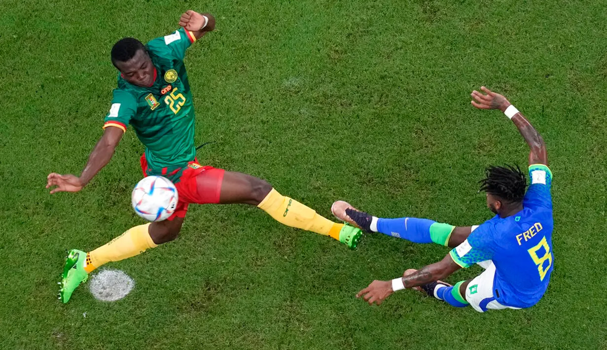 Pemain Kamerun Tolo Nouhou mencoba untuk memblokir tendangan dari pemain Brasil Fred (kanan) pada pertandingan sepak bola Grup G Piala Dunia 2022 di Stadion Lusail, Lusail, Qatar, 2 Desember 2022. Kamerun menang 1-0 atas Brasil, namun tetap tak lolos ke babak selanjutnya. (AP Photo/Thanassis Stavrakis)