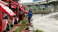 Petugas pemadan kebakaran menyedot air banjir di kawasan Cipinang Melayu, Jakarta, Minggu (21/2/2021). Suku Dinas Pemadam Kebakaran Jakarta Timur mengerahkan 20 mobil pompa untuk menyedot air yang membanjiri RW 04 Kelurahan Cipinang Melayu untuk mengurangi debit air. (Liputan6.com/Faizal Fanani)