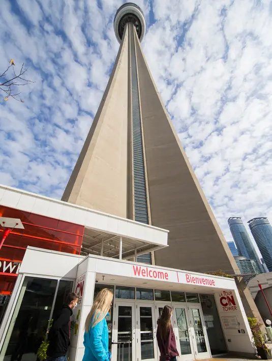 Orang-orang yang memakai masker berjalan melewati pintu masuk CN Tower di Toronto, Kanada, pada 3 Oktober 2020. CN Tower kembali ditutup untuk umum pada Sabtu (3/10) di tengah melonjaknya kasus COVID-19. (Xinhua/Zou Zheng)