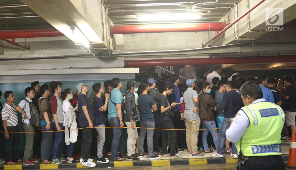 Antrean pengunjung di lantai area parkir untuk memasuki Nike Bazaar di Mal Grand Indonesia, Jakarta, Rabu (23/8). Mereka mengantre demi mendapat stempel agar bisa mengakses diskon sepatu hingga 90 persen. (Liputan6.com/Immanuel Antonius)