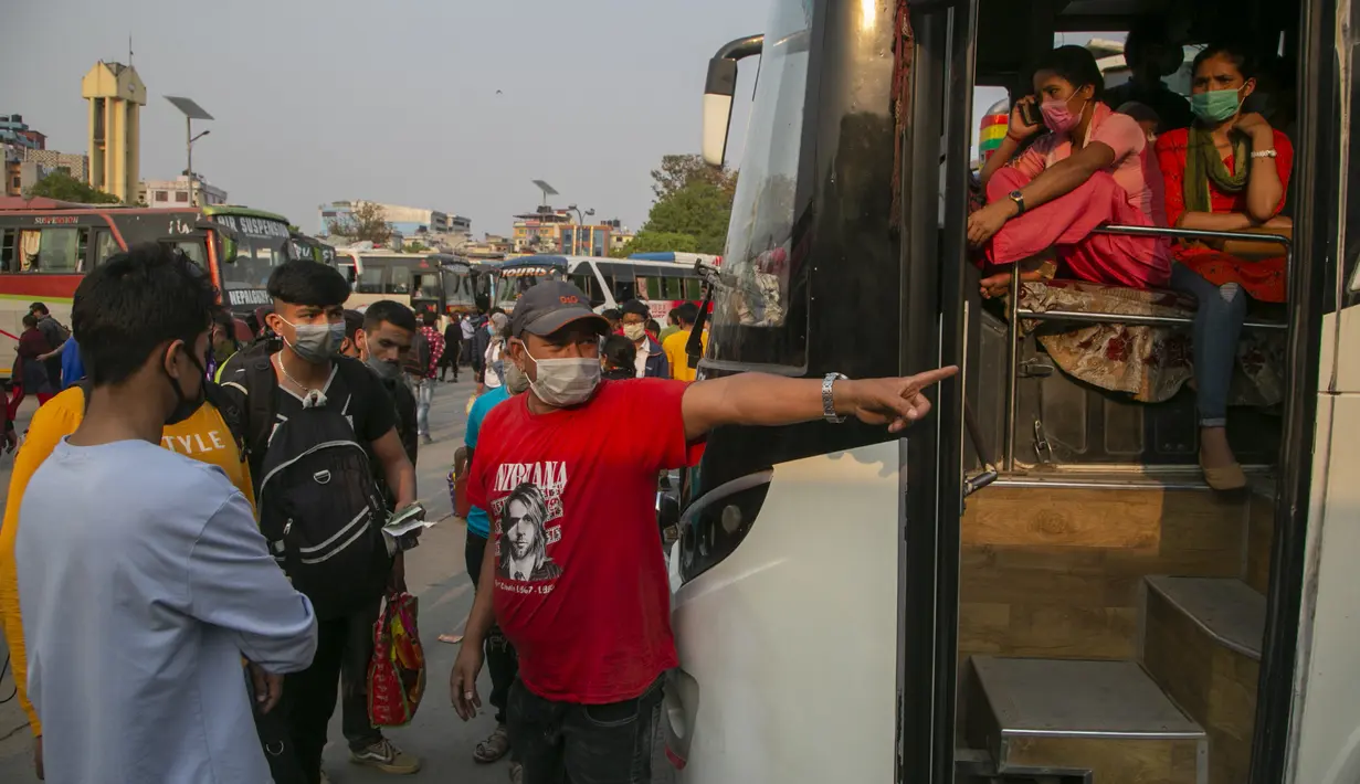 Seorang sopir menunjukkan bus kepada penumpang untuk kembali ke desa mereka sehari sebelum lockdown di Kathmandu, Rabu (28/4/2021). Puluhan ribu orang meninggalkan ibu kota Nepal sehari menjelang lockdown selama 15 hari yang diberlakukan karena melonjaknya kasus COVID-19 (AP Photo/Niranjan Shrestha)