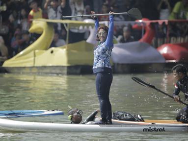 Menteri Kelautan dan Perikanan, Susi Pudjiastuti, menyapa penonton saat bermain paddle board di Danau Sunter, Jakarta, Minggu (25/2/2018). Kegiatan ini dilakukan dalam rangka Festival Danau Sunter. (Bola.com/Okie Prabhowo)