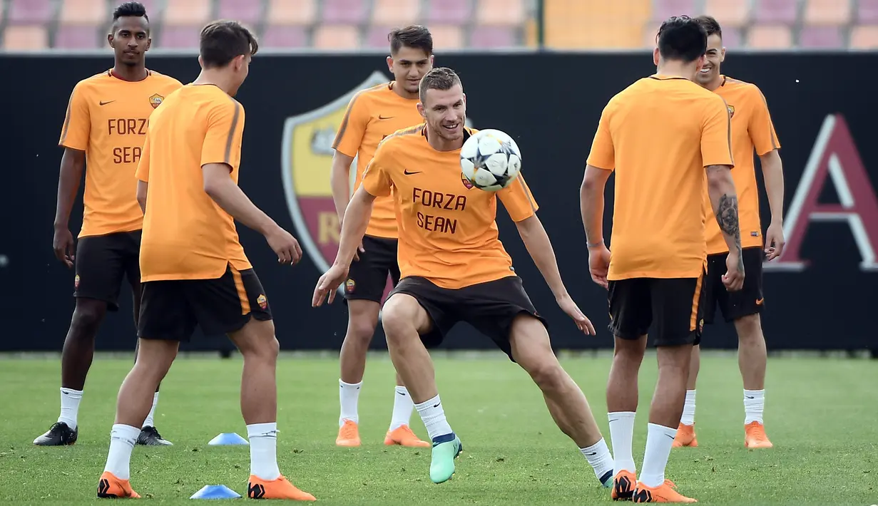 Pemain AS Roma, Edin Dzeko (tengah) bermain bola saat sesi latihan di Trigoria Sports Centre, Roma, Italia, Selasa (1/5). Roma harus menang 3-0 di Olimpico untuk melaju ke final. (FILIPPO MONTEFORTE / AFP)