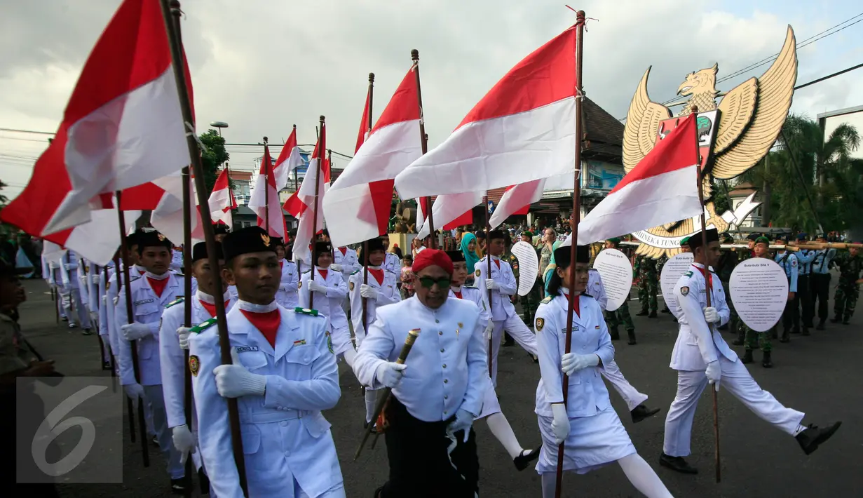 Peserta membawa bendera Merah Putih saat mengikuti pawai dengan membawa lambang Garuda Pancasila di Jl Malioboro, Yogyakarta, (01/6/2016).Pawai di selenggarakan untuk memperingati hari lahir Pancasila.(Boy Harjanto)