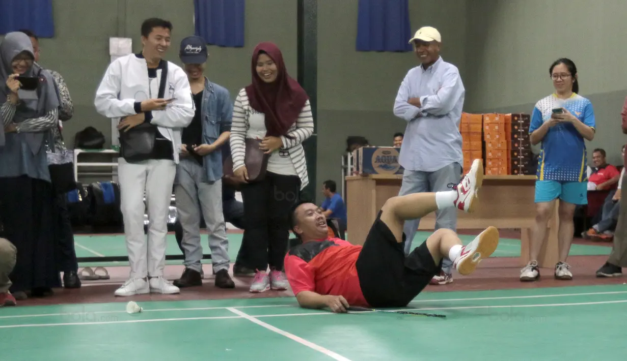 Menpora, Imam Nahrawi terjatuh saat gagal mengembalikan kok ke arah Kevin Sanjaya- Marcus Gideon pada laga eksebisi bulutangkis di Gedung Kemenpora, Senayan, Jakarta, (28/11/2017). Kevin-Marcus menang 21-13, 16-21 dan 27-25.(Bola.com/Nicklas Hanoatubun)