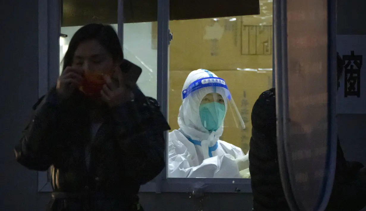 Seorang pekerja yang mengenakan pakaian pelindung menunggu untuk melakukan tes COVID-19 di tempat pengujian virus corona di Beijing, Rabu (9/11/2022). Lonjakan kasus COVID-19 telah mendorong penguncian di pusat manufaktur China selatan Guangzhou, menambah keuangan tekanan yang telah mengganggu rantai pasokan global dan secara tajam memperlambat pertumbuhan ekonomi terbesar kedua di dunia itu. (Foto AP/Mark Schiefelbein)