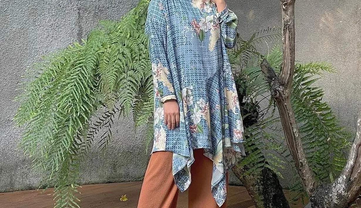 Kombinasi hijab warna biru earthy yang dipadukan dengan busana bermotif dan celana warna brick juga tak kalah kece. (Instagram/riamiranda).