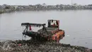 Petugas dibantu Alat berat mengeruk lumpur dan sampah yang mengendap di Waduk Pluit, Jakarta, Rabu (30/11). Pengerukan dilakukan untuk mengantisipasi banjir, seiring dengan datangnya musim hujan. (Liputan6.com/Immanuel Antonius)