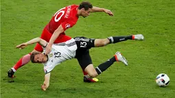 Pemain Jerman, Thomas Muller, terjatuh saat berebut bola dengan pemain Polandia, Grzegorz Krychowiak, pada laga kedua Grup C Piala Eropa 2016 di Stade de France, Jumat (17/6/2016) dini hari WIB. (Reuters/Charles Platiau)