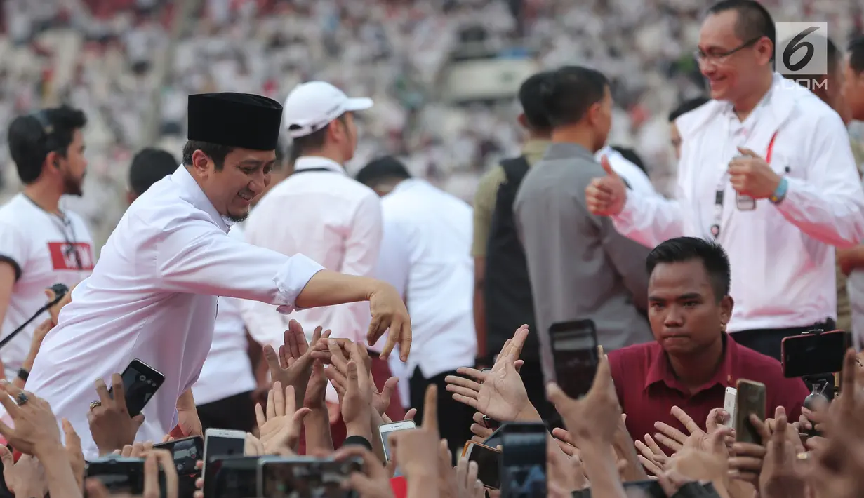 Ustaz Yusuf Mansur bersalaman dengan pendukung pasangan Capres dan Cawapres nomor urut 01, Jokowi - Ma'ruf Amin saat mengikuti kampanye akbar bertajuk 'Konser Putih Bersatu di Stadion Gelora Bung Karno (SGBK), Jakarta, Sabtu (13/4). (Kapanlagi.com/Budi Santoso)