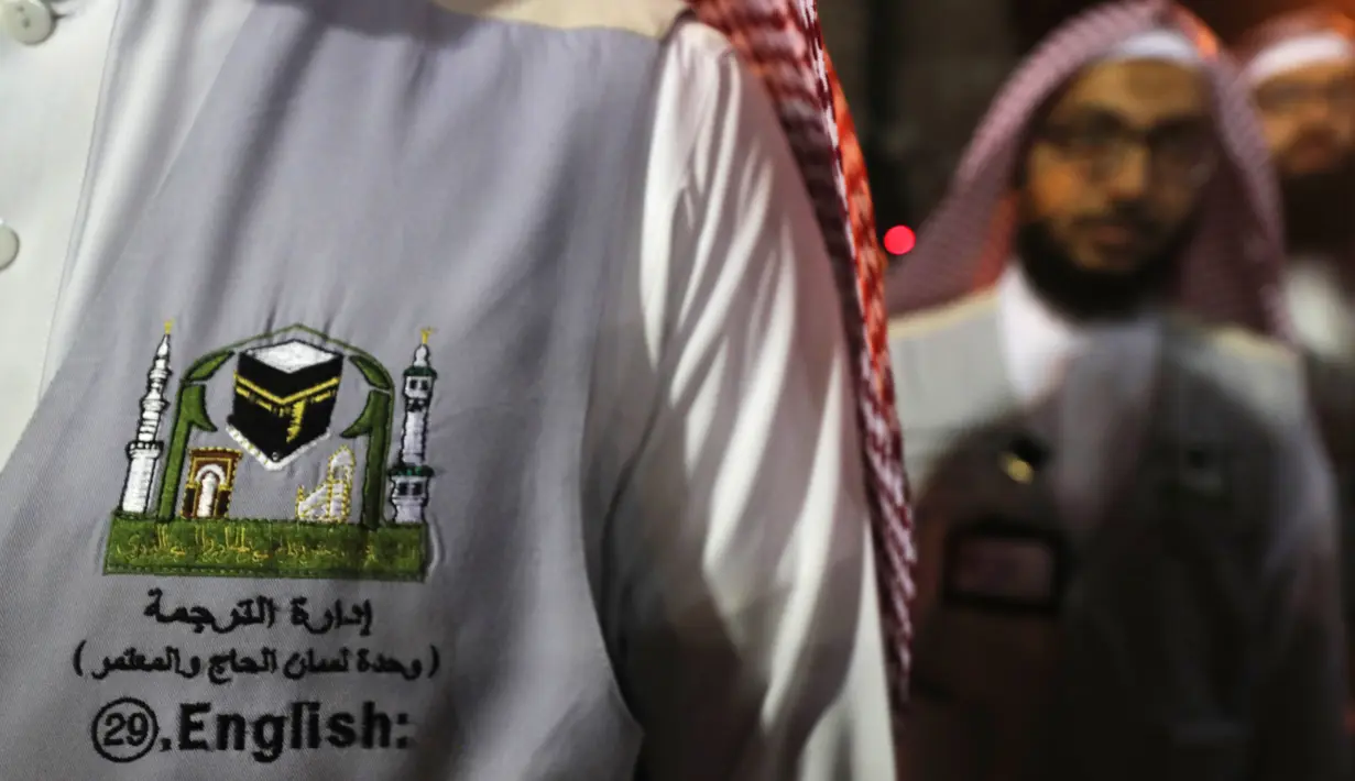 Seorang penerjemah menunggu untuk membantu jemaah haji di kota suci Islam, Makkah, 17 Agustus 2018. Pemerintah Arab Saudi mengerahkan para penerjemah dari berbagai bahasa yang bekerja 24 jam per hari untuk membantu jemaah. (AFP/AHMAD AL-RUBAYE)