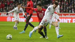 Penyerang Paris Saint-Germain (PSG) Lionel Messi berebut bola dengan gelandang Lille Benjamin Andre dalam lanjutan Liga Prancis di Stadion Pierre-Mauroy, Senin (7/2/2022) dinihari WIB. PSG mengalahkan juara bertahan Lille dengan skor 5-1. (AP Photo/Michel Spingler)