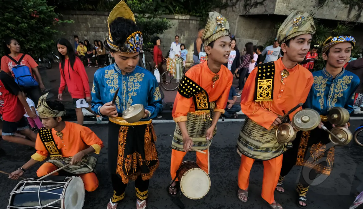 Aksi Mahasiswa saat memainkan alat tradisional saat car free day di Bundara HI, Jakarta, Minggu (26/4/2015). Mereka meminta sumbangan kepada warga untuk mengikuti Interntional Folklore Festival di Spanyol. (Liputan6.com/Faizal Fanani)