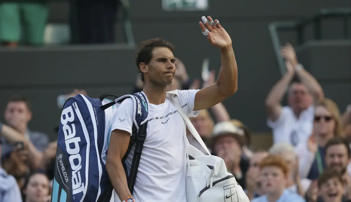 Rafael Nadal memberikan salam kepada penonton usai kalah dari Gilles Muller pada hari ketujuh di Wimbledon Tennis Championships 2017, London (10/7/2017). Nadal kalah 3-6, 4-6, 6-3, 6-4, 13-15. (AP/Tim Ireland)