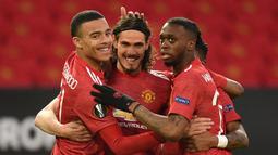 Striker Manchester United, Edinson Cavani (tengah) bersama rekan setim merayakan gol pertama yang dicetaknya ke gawang Granada dalam laga leg kedua perempatfinal Liga Europa 2020/2021 di Old Trafford Stadium, Manchester, Kamis (15/4/2021). Manchester United menang 2-0 atas Granada. (AFP/Oli Scarff)