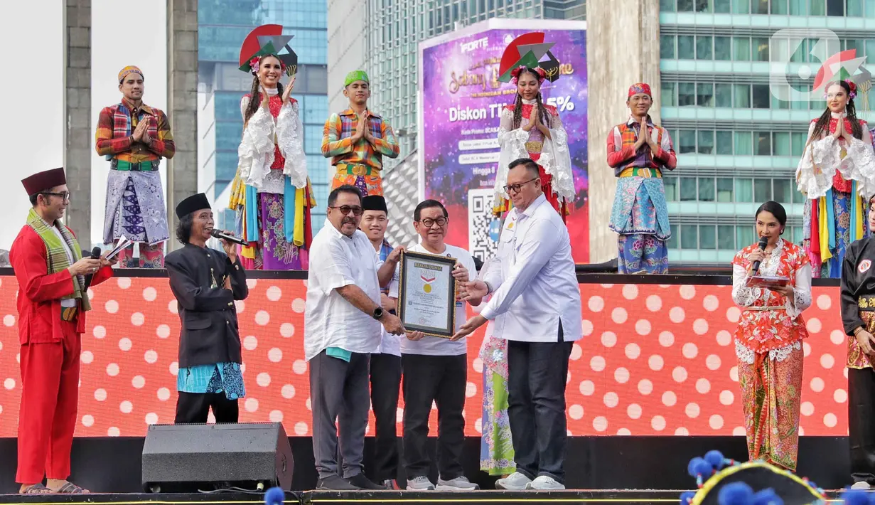 Perhelatan budaya ini mendapat penghargaan dari Museum Rekor Dunia Indonesia (MURI). Tampak dalam foto, Gubernur DKI Jakarta Pramono Anung dan Wakil Gubernur Rano Karno menunjukan piagam Rekor MURI saat pertunjukan kolosal budaya pada Hari Bebas Kendaraan Bermotor (HBKB) atau Car Free Day (CFD)di kawasan Bundaran Hotel Indonesia (HI), Jakarta, Minggu (6/7/2025). (Liputan6.com/Angga Yuniar)