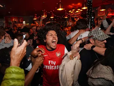 Suka cita menyelimuti para suporter Arsenal setelah The Gunners memastikan diri sebagai juara Liga Inggris musim 2025/2026. (AP Photo/Alberto Pezzali)