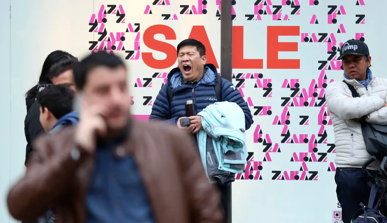 Seorang pria menguap saat menunggu di luar toko selama Boxing Day di Oxford Street, London, Rabu (26/12). Pada Boxing Day ini, hampir semua toko yang memberikan pesta diskon diserbu para pembeli dan terjadi antrean panjang. (Isabel Infantes/PA via AP)