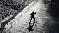 Seorang atlet melakukan pemanasan di lintasan bersalju dalam kejuaraan Nordic Combined World Cup di Austria. (Foto: AP/Matthias Schrader)