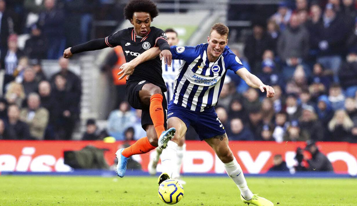 Pemain Brighton and Hove Albion, Dan Burn, berebut bola dengan gelandang Chelsea, Willian, pada laga Premier League di Stadion AMEX, Rabu (1/1/2020). Kedua tim bermain imbang 1-1. (AP/(Gareth Fuller)