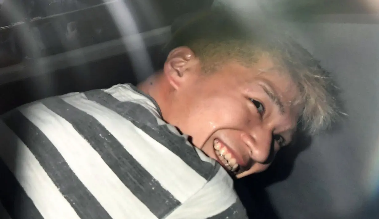 Ekspresi Satoshi Uematsu saat berada di dalam mobil di kantor polisi Tsukui, Jepang, Rabu (27/7). Satoshi dengan menggunakan pisau membunuh setidaknya 19 orang dan melukai 26 lainnya pada Selasa (28/7) dini hari. (REUTERS/Issei Kato)