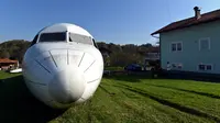 Badan pesawat Fokker-100 terlihat diparkir di halaman rumah warga setempat di Strmec Stubicki, dekat Zagreb, Kroasia, 26 Oktober 2019. Robert Sedlar (50) mengubahnya menjadi objek wisata di mana pesawat bisa disewakan untuk semua jenis acara dan pesta. (Denis LOVROVIC/AFP)