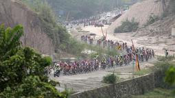 Aksi para pebalap sepeda selepas start dari Kantor Bupati Padang Pariaman dalam Etape 2 Tour de Singkarak 2015, Minggu (4/10/2015). (Bola.com/Arief Bagus)