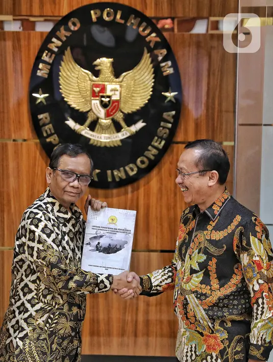 Menteri Koordinator Bidang Politik, Hukum, dan Keamanan (Menko Polhukam) Mahfud MD (kiri) menerima berkas laporan terkait investigasi tragedi Kanjuruhan dari Ketua Komnas HAM Ahmad Taufan Damanik (kanan) di Kantor Menko Polhukam, Jakarta, Kamis (3/11/2022). Menko Polhukam mewakili Presiden Joko Widodo atau Jokowi menerima laporan terkait investigasi tragedi Kanjuruhan yang berisi rekomendasi untuk membekukan seluruh kegiatan PSSI. (Liputan6.com/Angga Yuniar)