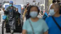 Seorang pekerja pemeliharaan yang mengenakan masker menarik gerobak di sepanjang jalan di Beijing, Rabu (6/7/2022). Lockdown dan pengujian massal berulang kali terjadi di China. Ini merupakan bagian dari kebijakan nol-Covid yang bertujuan untuk memberantas semua wabah. (AP Photo/Mark Schiefelbein)