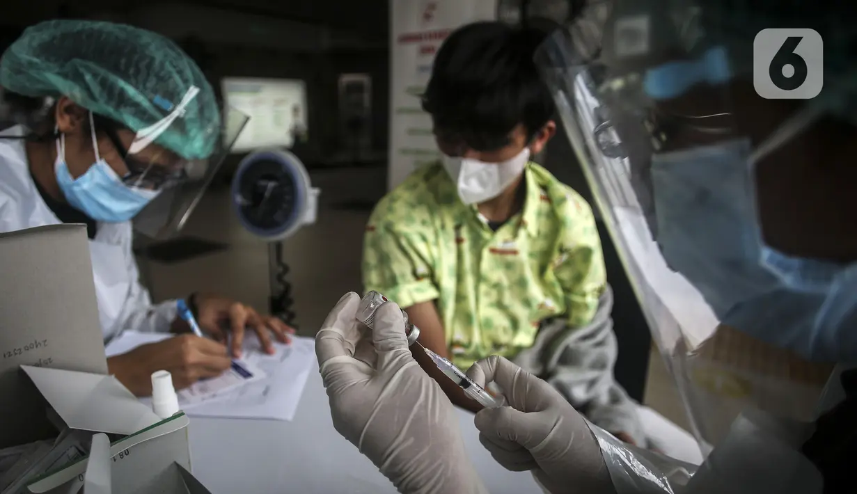 Petugas menyiapkan vaksin COVID-19 saat kegiatan vaksinasi gratis di Stasiun MRT, Jakarta, Jumat (23/7/2021). Penyuntikan vaksin COVID-19 dosis pertama tersebut berlangsung pada 22-24 Juli 2021. (Liputan6.com/Johan Tallo)