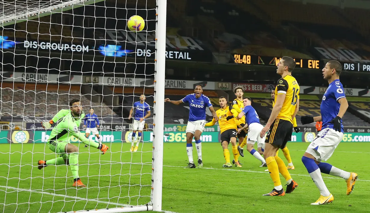 Kiper Wolverhampton Wanderers, Rui Patricio gagal menjangkau tandukan bek Everton, Michael Keane (ketiga dari kanan) yang berbuah gol kedua dalam laga lanjutan Liga Inggris 2020/21 di Molineux Stadium, Selasa (12/1/2021). Wolverhampton Wanderers kalah 1-2 dari Everton. (AFP/Richard Heathcote/Pool)