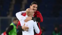 Penyerang AC Milan, Zlatan Ibrahimovic memeluk pelatih Stefano Pioli usai mengalahkan Atalanta pada pertandingan Liga Serie A Italia di stadion Atleti Azzurri d'Italia di Bergamo, Senin (24/5/2021).  AC Milan mengakhiri Serie A 2020/2021 dengan finis sebagai runner up. (AFP/Marco Bertorello)