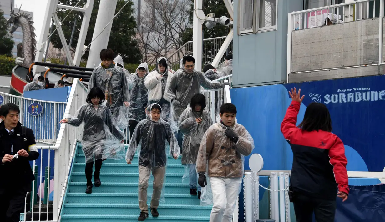 Instruktur memberikan bimbingan pelatihan kepada peserta yang mengikuti simulasi evakuasi anti-rudal di taman hiburan Tokyo Dome City, Jepang, (22/1). (AFP Photo/Toshifumi Kitamura)