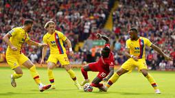 Pemain Liverpool Sadio Mane dilanggar oleh pemain Crystal Palace Jordan Ayew (kanan) pada pertandingan Liga Inggris di Stadion Anfield, Liverpool, Inggris, Sabtu (18/9/2021). Liverpool menang telak 3-0. (AP Photo/Jon Super)