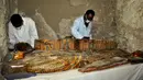 Arkeolog Mesir meneliti mumi yang ditemukan di sebuah pemakaman berumur 3.500 tahun, sebelah selatan kota Luxor, Selasa (18/4). Para arkeolog menemukan delapan mumi, peti mati kayu warna-warni serta lebih dari 1.000 patung pemakaman. (STRINGER/AFP)