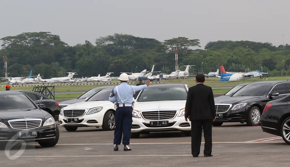 Petugas mengatur mobil yang membawa rombongan Raja Arab Saudi Salman bin Abdulaziz al-Saud di Bandara Halim Perdanakusuma, Rabu (3/1). Sejumlah mobil mewah terlihat bersiap untuk menjemput kedatangan Raja Salman. (Liputan6.com/Fery Pradolo)