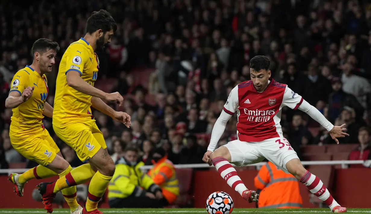 Penyerang Arsenal, Gabriel Martinelli mengontrol bola dari kawalan dua pemain Crystal Palace pada pertandingan lanjutan Liga Inggris di Stadion Emirates, London, Selasa (19/10/2021). Arsenal bermain imbang atas Crystal Palace 2-2. (AP Photo/Alastair Grant)