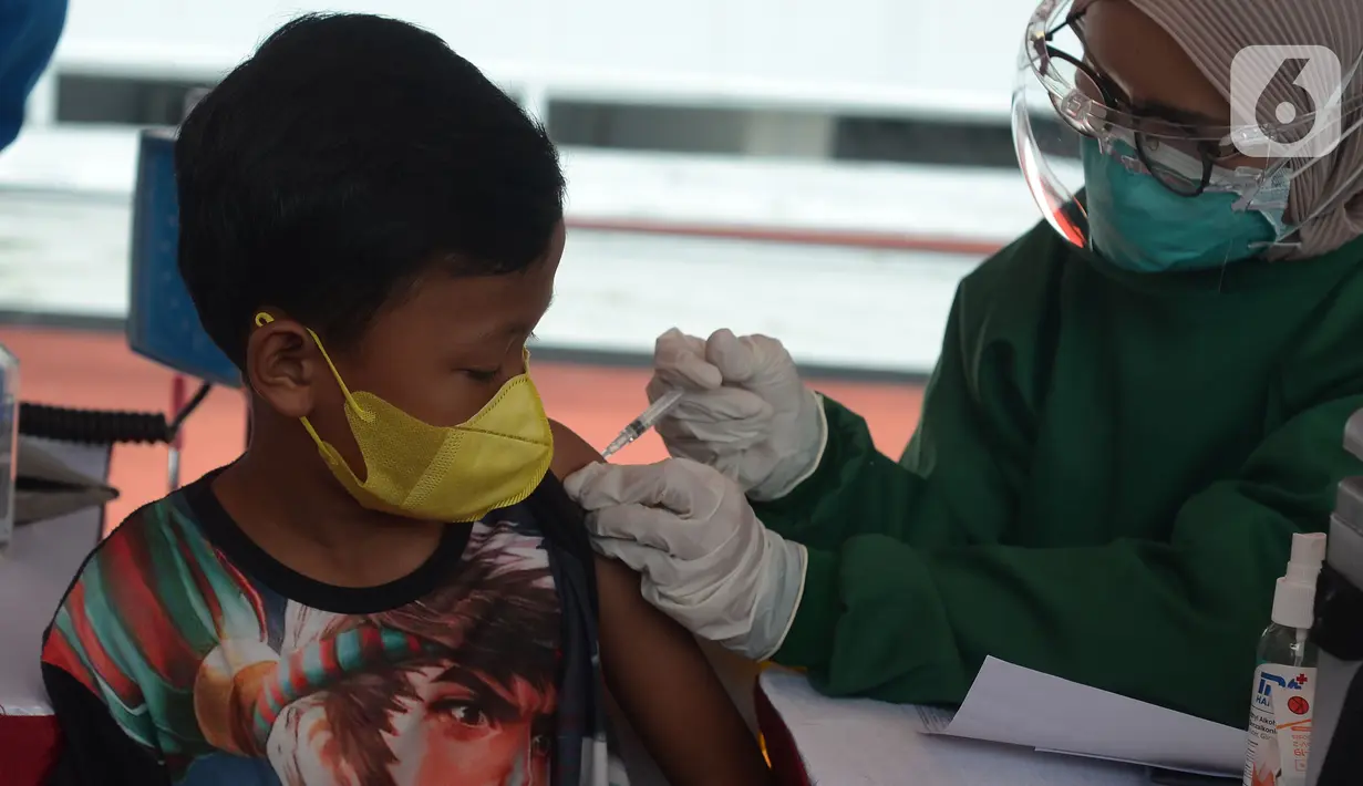 Seorang anak mendapatkan vaksin covid-19  di Stadion Utama Gelora Bung Karno (GBK), Senayan, Jakarta, Sabtu (3/7/2021). Pemprov DKI menggelar vaksinasi massal bagi anak usia 12-17 tahun di Stadion GBK selama dua hari, yakni pada 3-4 Juli 2021. (merdeka.com/Imam Buhori)