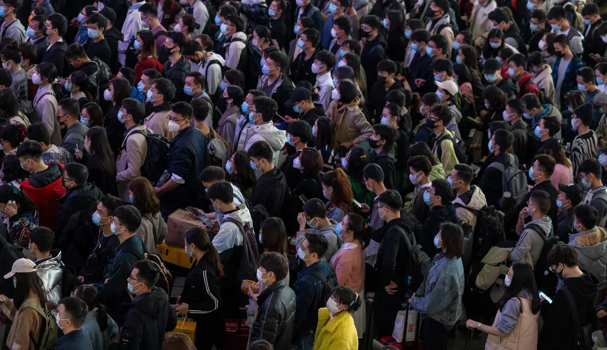 Pelancong yang mengenakan masker mengantre kereta di sebuah stasiun di Guangzhou di Provinsi Guangdong, China, Jumat (28/1/2022). Warga China melakukan perjalanan ke kampung halaman mereka untuk Tahun Baru Imlek, hari libur keluarga terbesar di negara itu. (Chinatopix via AP)