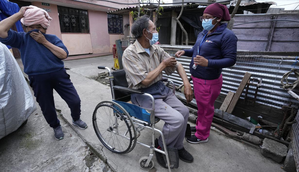 Seorang pria di kursi roda menyingsingkan lengan bajunya untuk vaksin COVID-19 di Quito, Ekuador, 26 Januari 2022. Brigade campuran dari pemerintah kota dan Kementerian Kesehatan mengunjungi lingkungan miskin untuk mendeteksi kasus COVID-19 dan melakukan vaksinasi. (AP Photo/Dolores Ochoa)