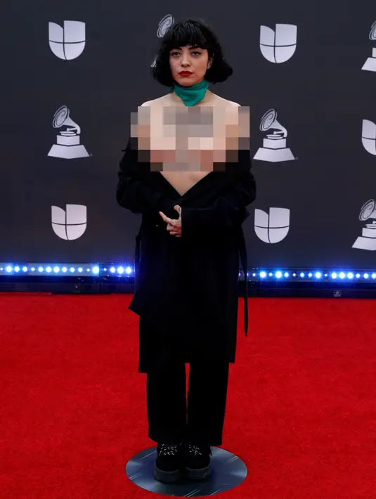 Penyanyi Chile Mon Laferte membuka bajunya saat berpose di karpet merah Latin Grammy Awards 2019, MGM Grand Garden Arena, Las Vegas, Amerika Serikat, Kamis (14/11/2019). Aksi mon juga sebagai bentuk dukungan bagi demonstran antipemerintah di Chile. (Bridget BENNETT/AFP)