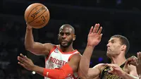 Guard Houston Rockets Chris Paul (kiri) mengumpan bola melewati center Los Angeles Lakers Brook Lopez pada lanjutan NBA 2017-2018 di Staples Center, Selasa (10/4/2018) Rabu (11/4/2018) WIB. (AP Photo/Mark J. Terrill)