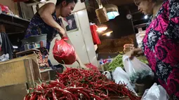 Pedagang cabai melayani pembeli di pasar di Jakarta, Jumat (20/4). Harga cabai dan bawang memasuki akhir pekan ini terpantau belum banyak berubah, cenderung mengalami penurunan. Pasokan yang cukup mendorong harga masih stabil. (Liputan6.com/Angga Yuniar)