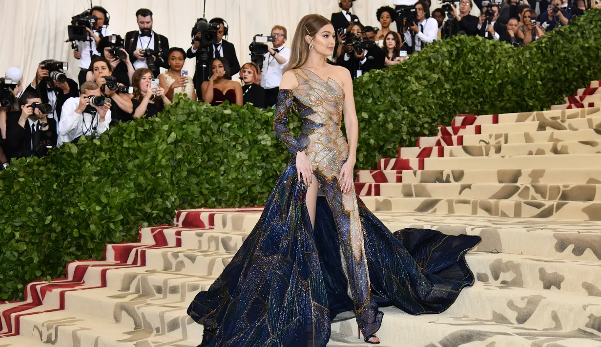 Model Gigi Hadid berpose saat menghadiri Met Gala 2018 di Metropolitan Museum of Art, New York (7/5). Tema Met Gala kali ini adalah "Heavenly Bodies: Fashion dan Catholic Imagination". (AP Photo/Charles Sykes)